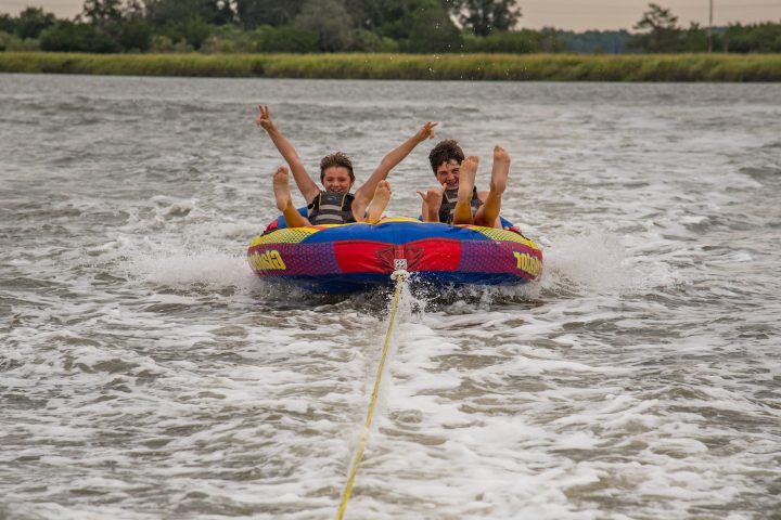 a man riding on the back of a boat in a body of water
