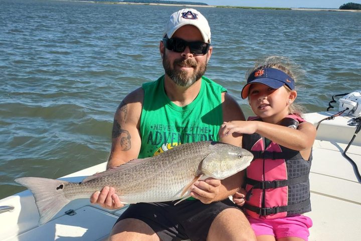 a man and woman sitting next to a body of water